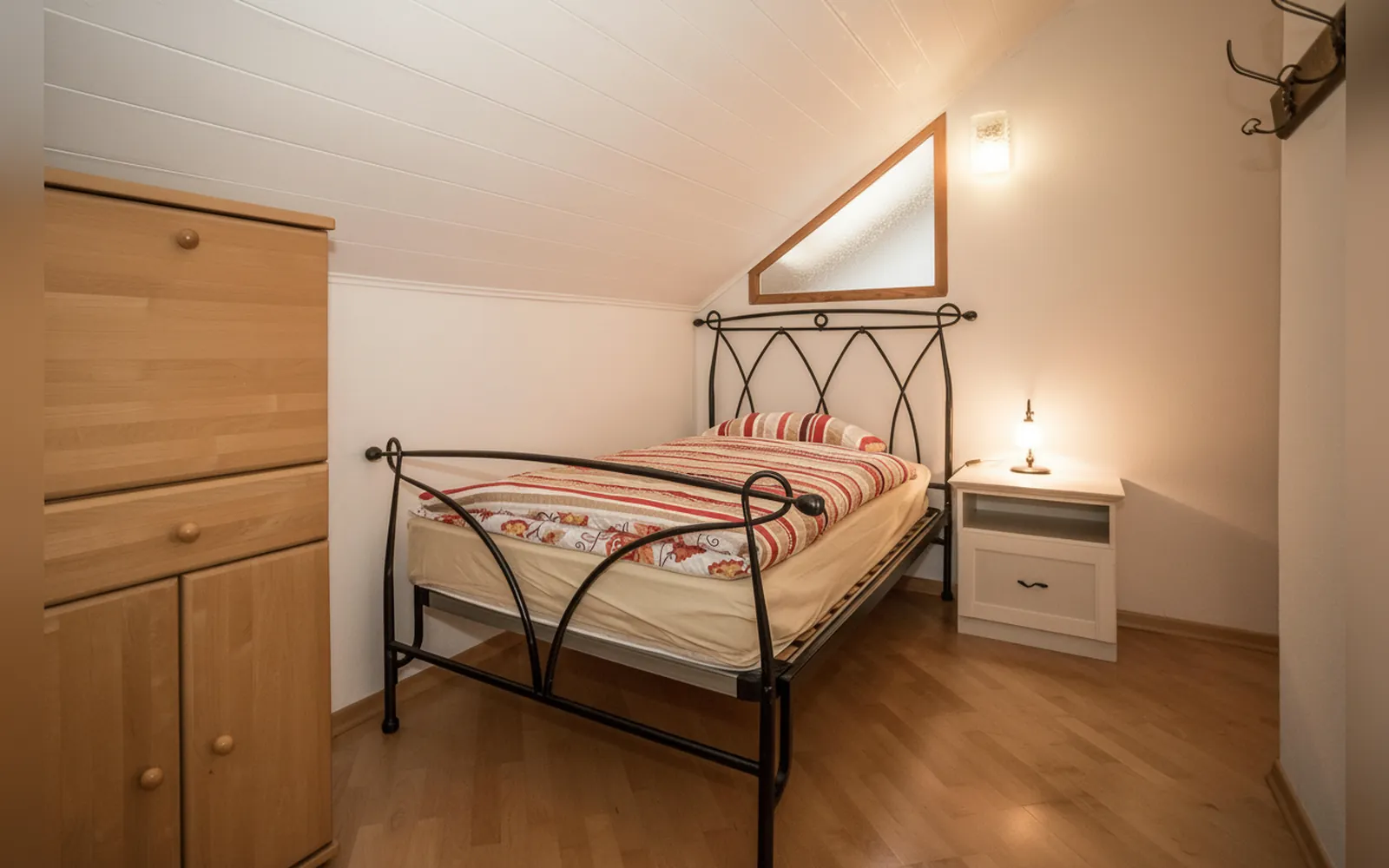 La seconda camera con il letto alla francese in ferro battuto sotto la finestra a triangolo
